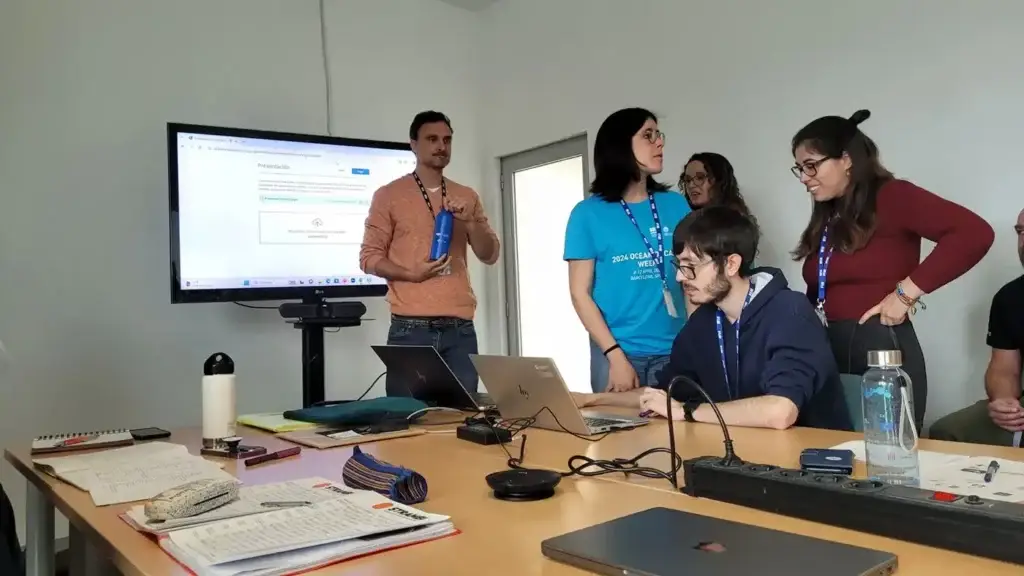 Réunion de l'equipe du projet CAOUA dans une salle avec des écrans et des ordinateurs