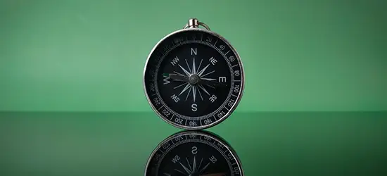 photo d'une boussole moderne noir sur fond vert pour identifier la désorientation