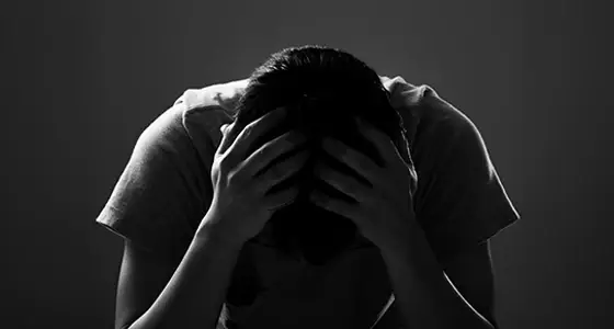 homme photo noir et blanc se tenant la tête synonyme de dépression